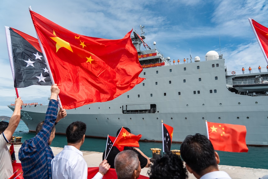 papua new guinea and chinese flags flown in front of a ship