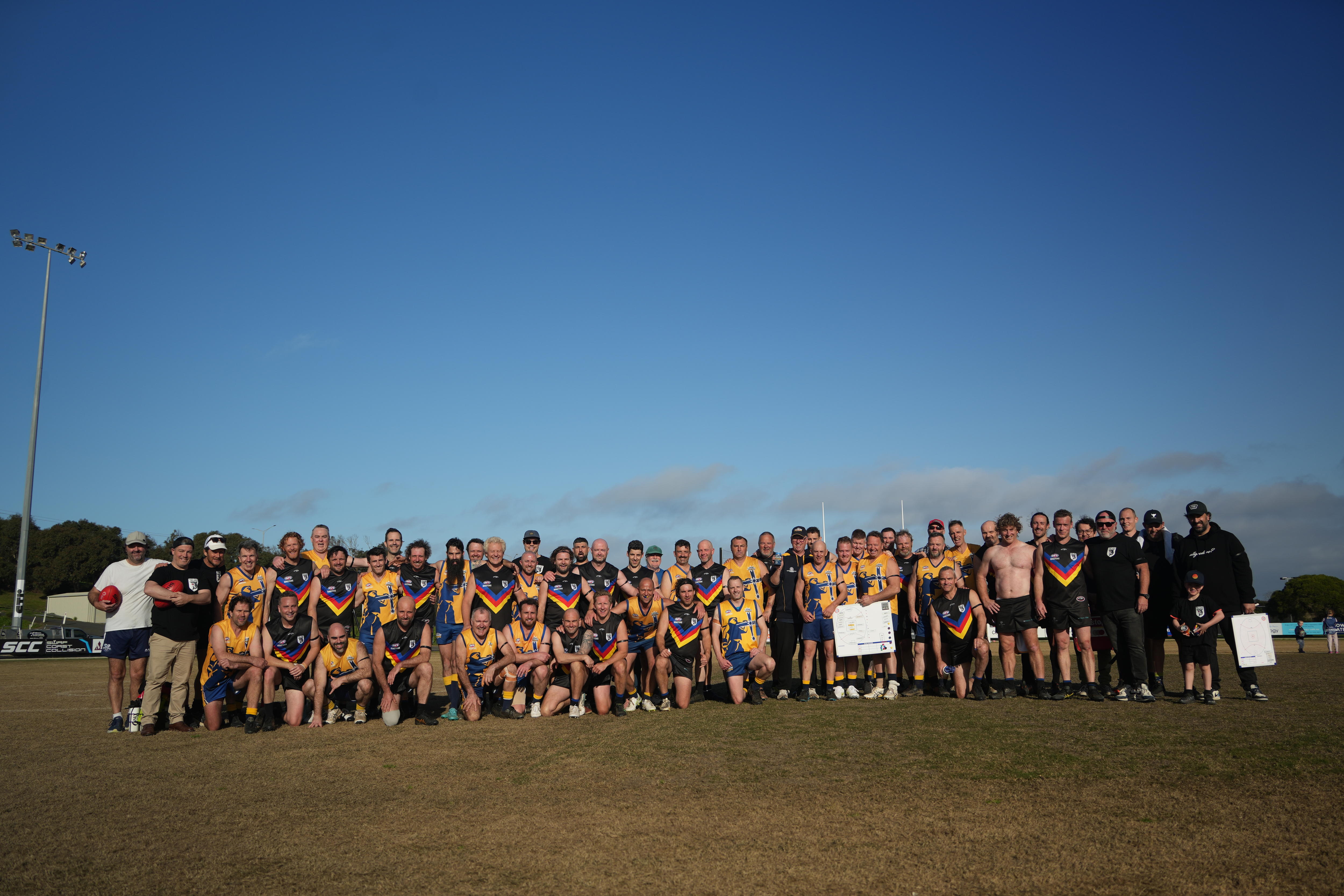 All players frmo both the South Coast Sharks and Ballarat Diggers stand together for a joint team photo on the oval
