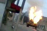 A Syrian army tank burns in a street of the city of Rastan.