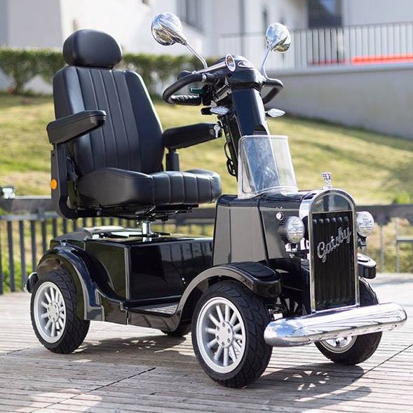 A 1930s style mobility scooter sitting on the footpath.