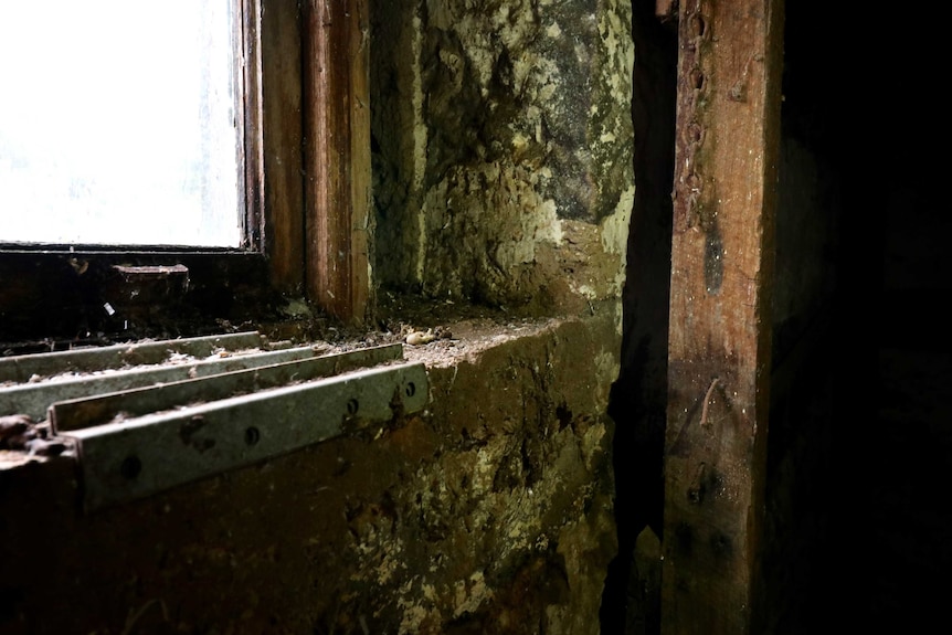 Burn marks dot a pillar in an old, unused blacksmith's room.