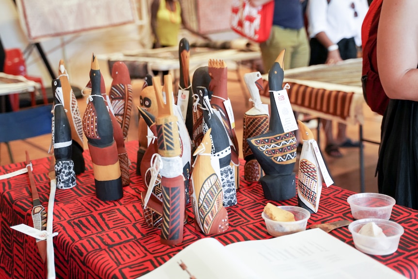 A collection of small wooden, handmade Aboriginal art statues sit on a table at the Tiwi Islands art sale.