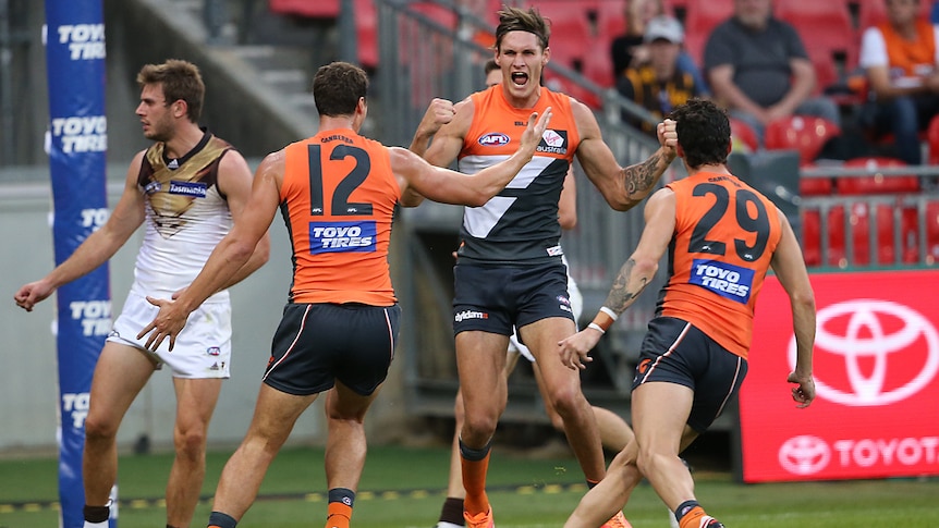 Giants' Rory Lobb celebrates with team-mates a goal for GWS against Hawthorn at Sydney Showgrounds.