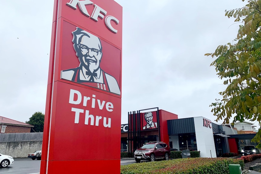 A driveway with a sign saying "KFC Drive Thru".