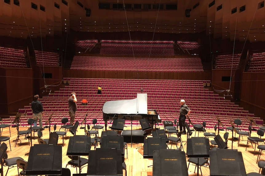 A grand piano sits on stage at the Sydney Opera House in front of an empty auditorium