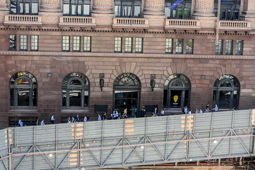 City workers walking behind a barrier in Martin Place.