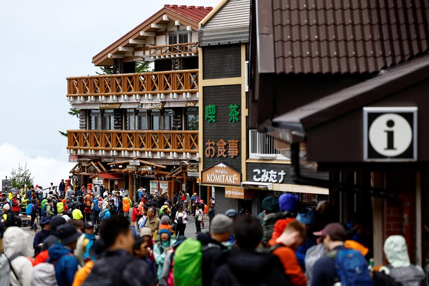 A crowd of mountain climbers gathered outside an inn in Japan's Mount Fuji