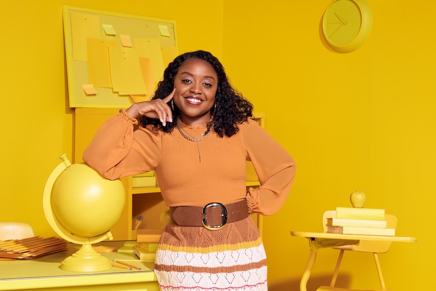 Quinta Brunson poses in front of a yellow background.