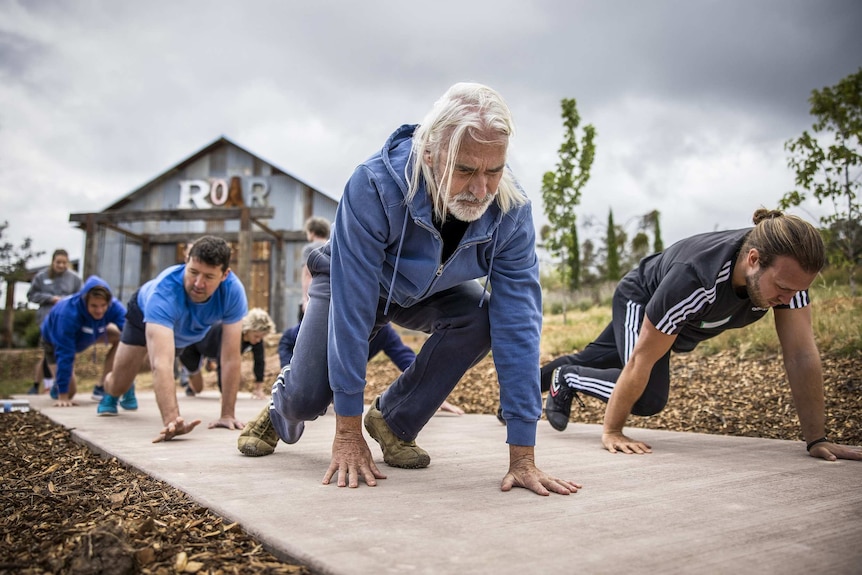 A group of workshop participants do yoga