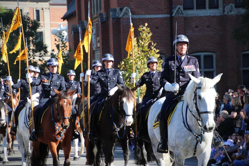 Police on horseback march in a parade