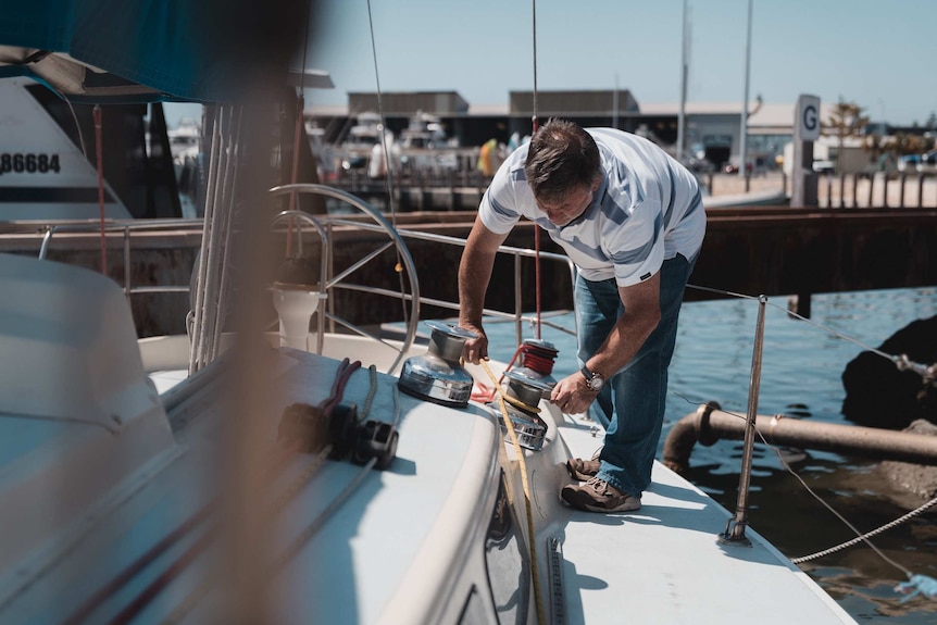 Mike Walker tying a rope on a yacht.