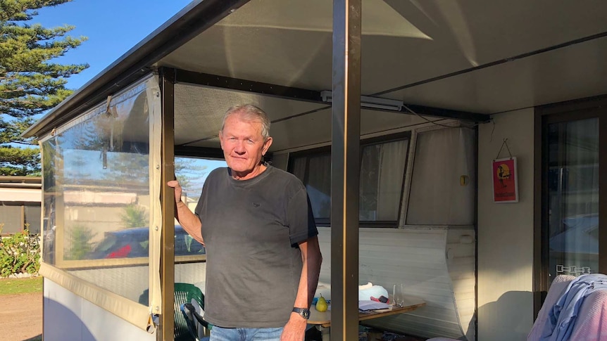 Caravan owner Dennis McKeown stands on the deck outside of his caravan at the Werri Beach Holiday Park in Gerringong.