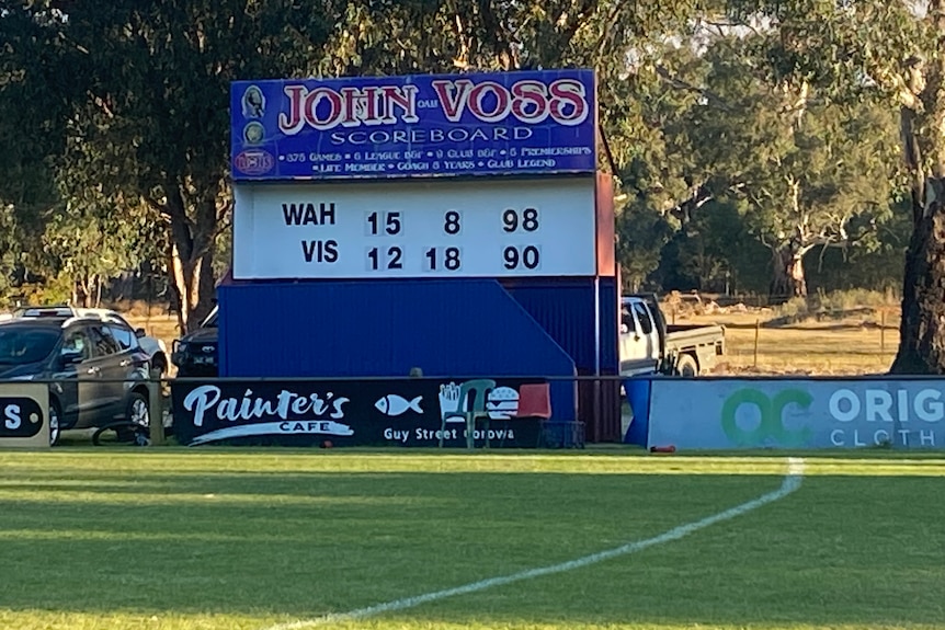 A country football scoredboard showing Wahgunyah beating the visitors by 98 points to 90 on a green oval