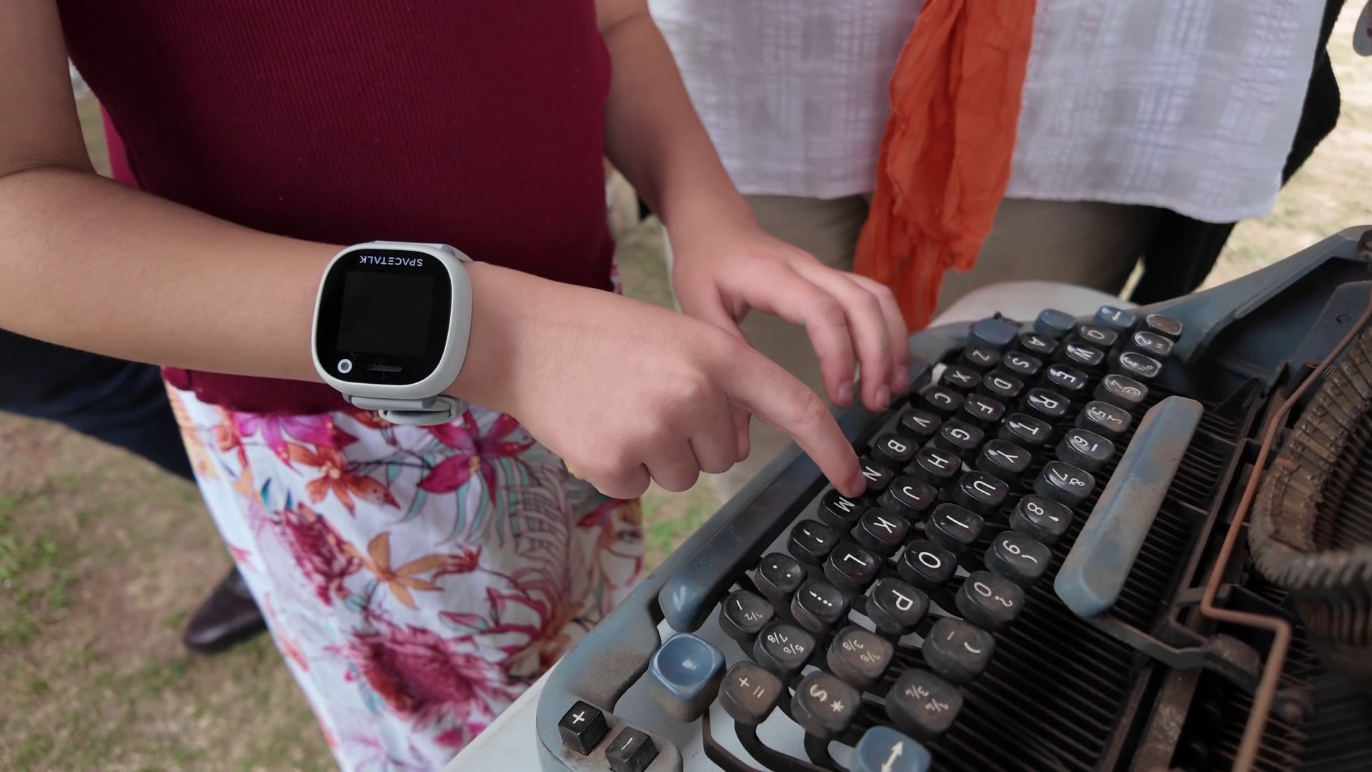 Una joven con un reloj inteligente coloca las llaves en una vieja máquina de escribir mecánica.