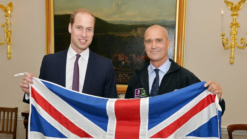 Polar explorer Henry Worsley (R) and Britain's Prince William (L) pose with a Union flag at Kensington Palace in London.