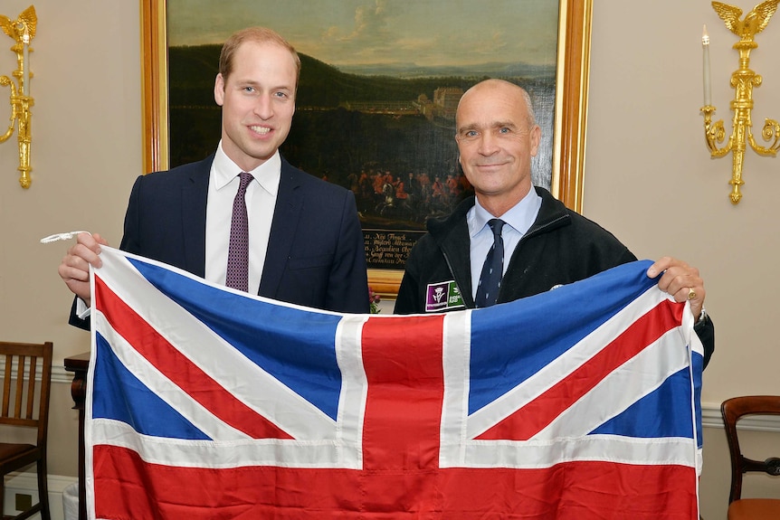 Polar explorer Henry Worsley (R) and Britain's Prince William (L) pose with a Union flag at Kensington Palace in London.