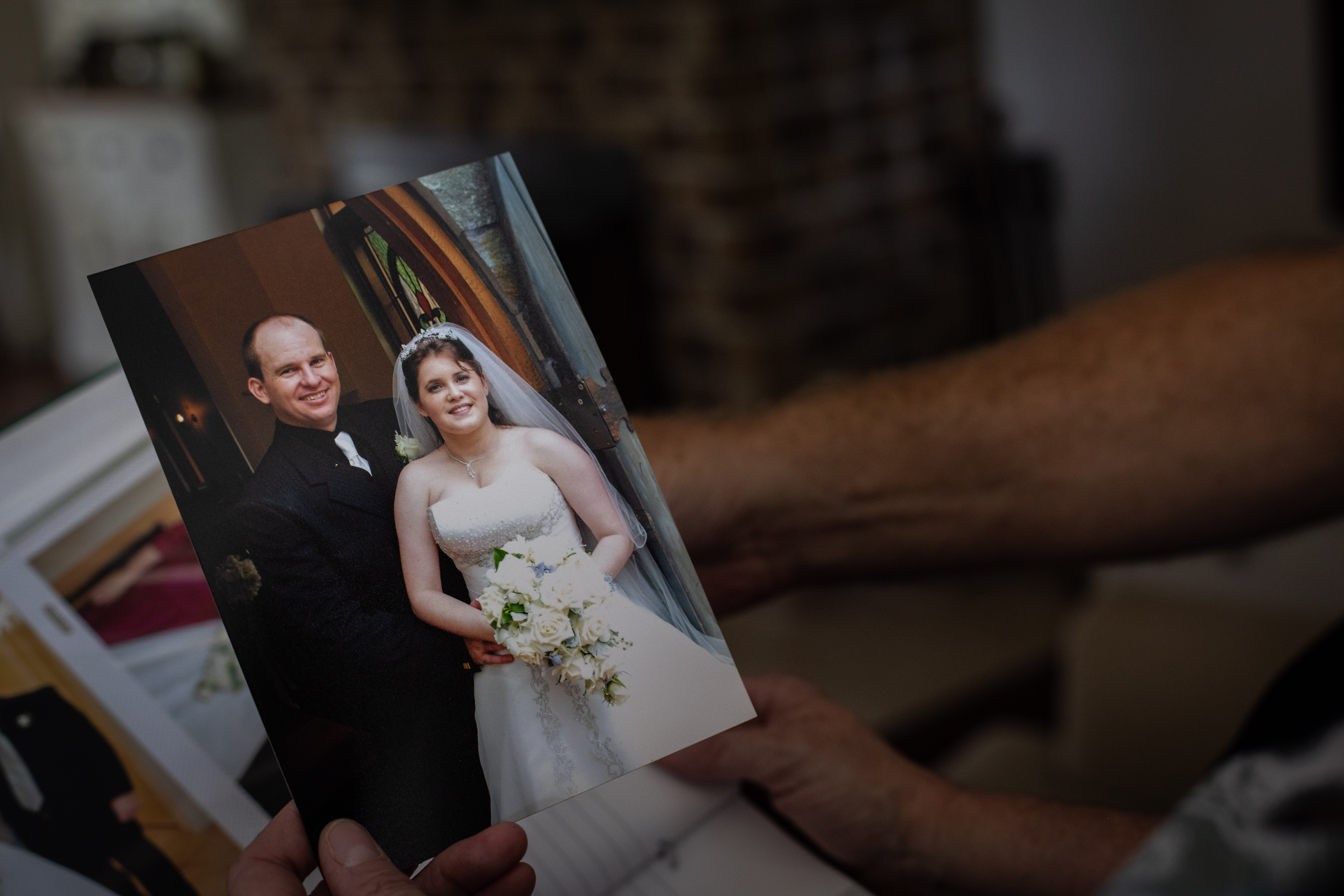 Two people holding a wedding photo.