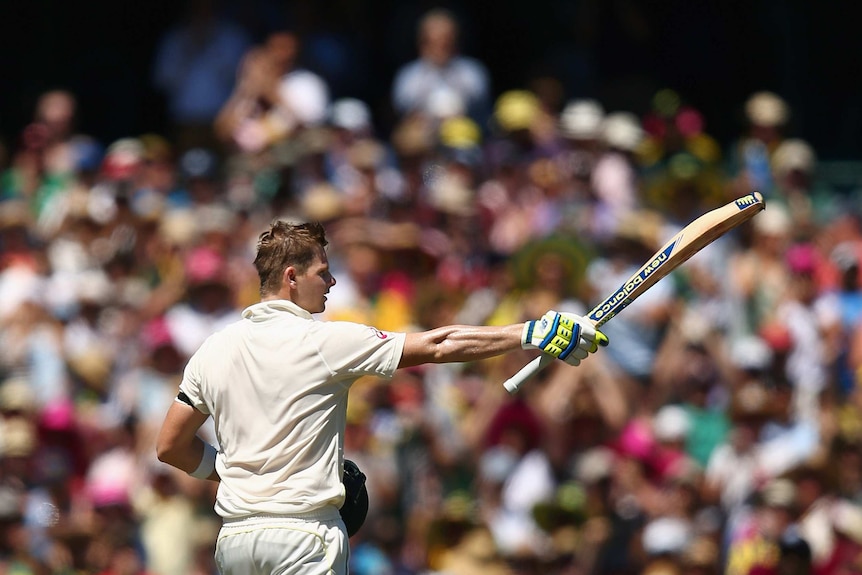 Australia's Steve Smith raises his bat after reaching his century on day two at the SCG