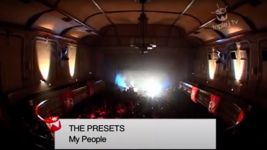 A screenshot of The Presets performing My People live at Mebourne's Ormond Hall with bright lights