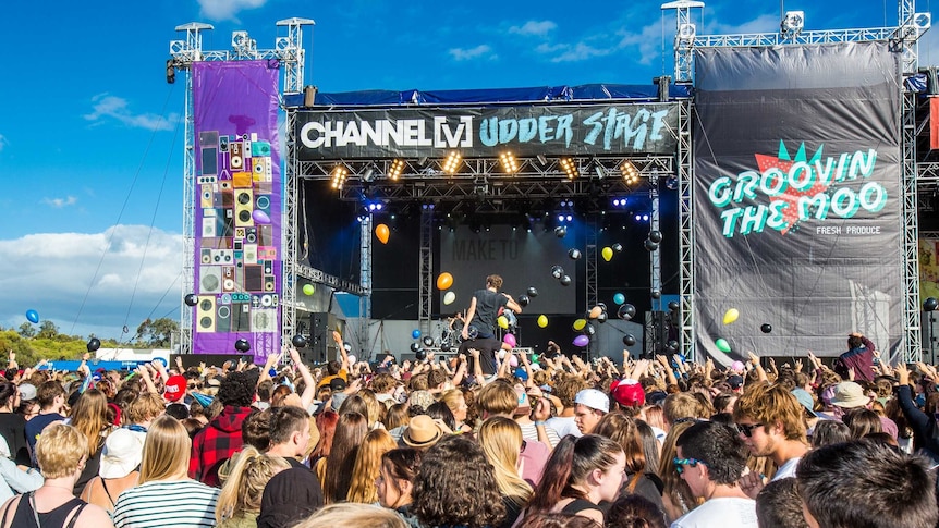 Fans raise their arms in front of a stage at last year's Groovin the Moo festival in Bunbury