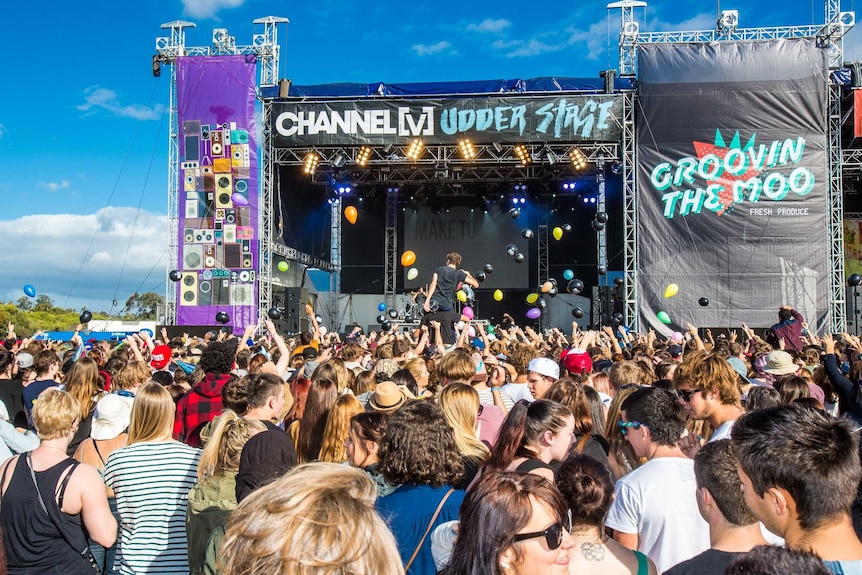 Fans raise their arms in front of a stage at last year's Groovin the Moo festival in Bunbury