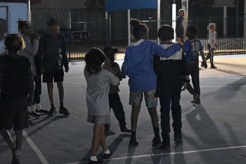 Young kids play on a basketball court
