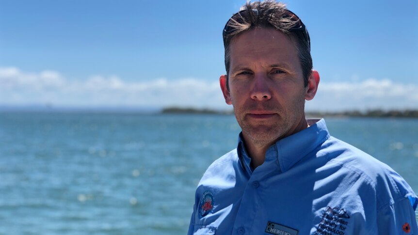 A man wearing a blue shirt looks concerned as he stands in front of Deception Bay
