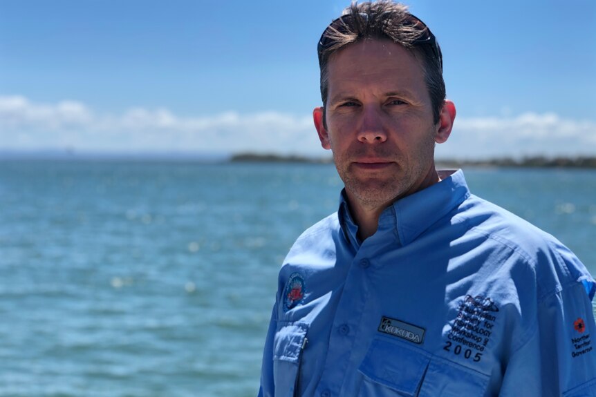 A man wearing a blue shirt looks concerned as he stands in front of Deception Bay