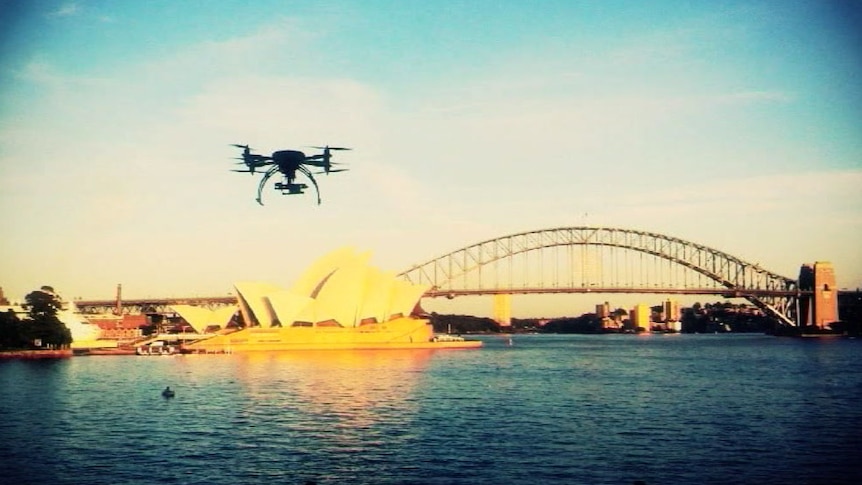 A remote-control helicopter, fitted with a camera, flies over Sydney Harbour