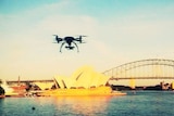 A remote-control helicopter, fitted with a camera, flies over Sydney Harbour