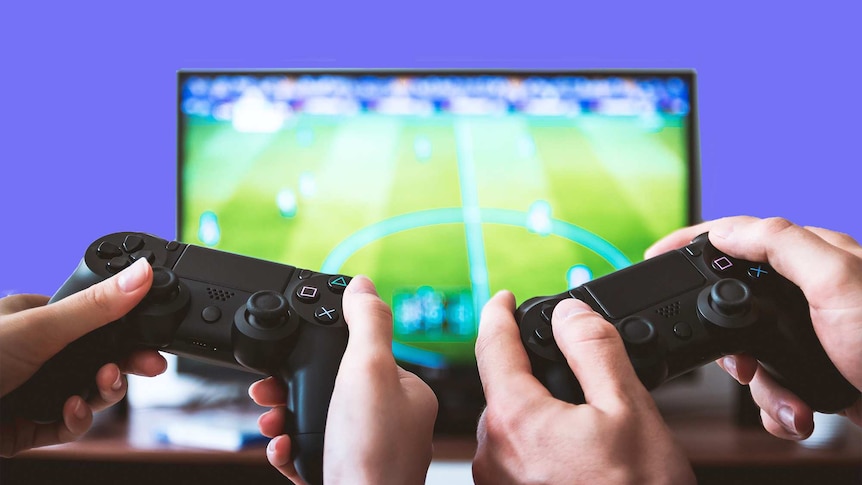 Two people hold video game controllers in front of a television showing scenes from a soccer game.