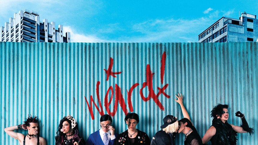 Image shows YUNGBLUD dressed up as 7 different characters & the word 'weird!' graffitied on a fence