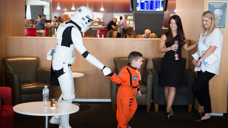 A Stormtrooper escorts Dwayne Franke through Adelaide Airport.