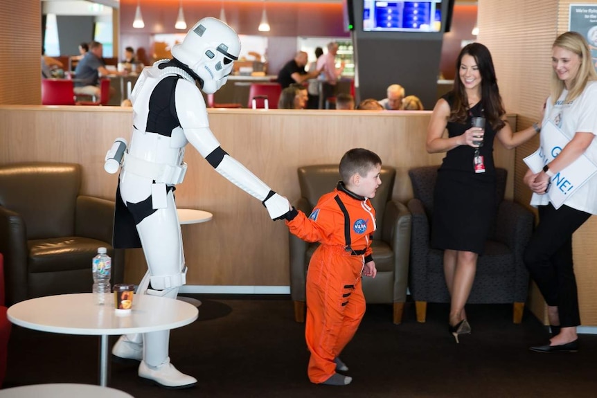 A Stormtrooper escorts Dwayne Franke through Adelaide Airport.