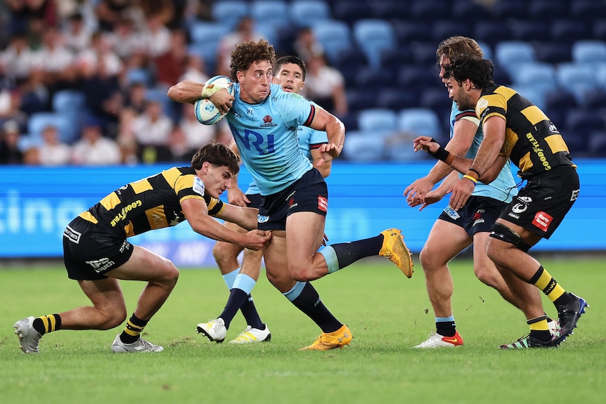 A man looks to offload during a Super Rugby match