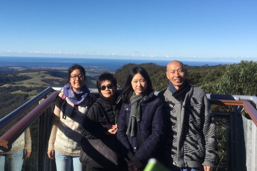 Liana Tran stands next to her mother, father and younger sister.