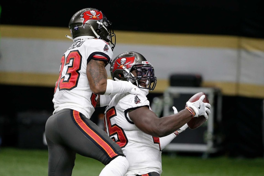 Two tampa bay buccaneers american football players celebrate after an interception