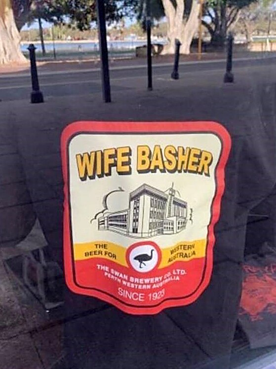 A black t-shirt with an Emu Export beer label on the front with the words Emu Export changed to Wife Basher.
