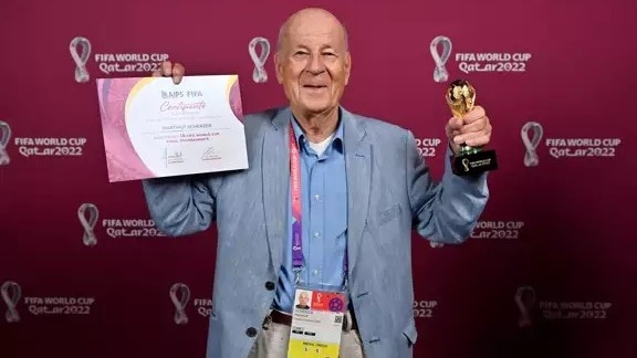 Hartmut Scherster holding up a certificate and trophy.