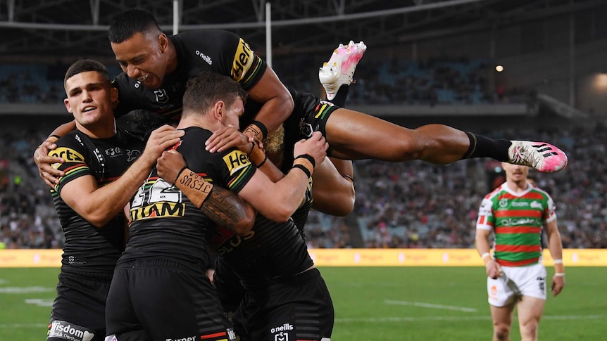 Stephen Crichton jumps over the top of a pack of Penrith Panthers players to celebrate a try against the South Sydney Rabbitohs.