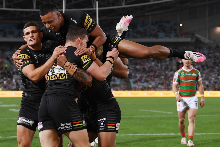 Stephen Crichton jumps over the top of a pack of Penrith Panthers players to celebrate a try against the South Sydney Rabbitohs.