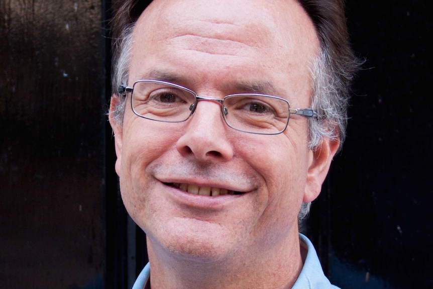 Portrait of a caucasian man with glasses smiling and looking at camera