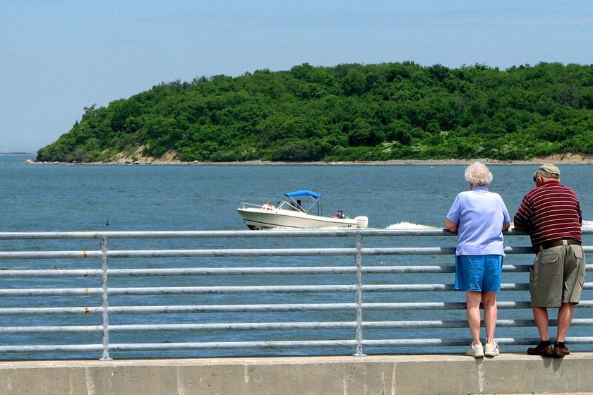 An elderly couple look across ocean