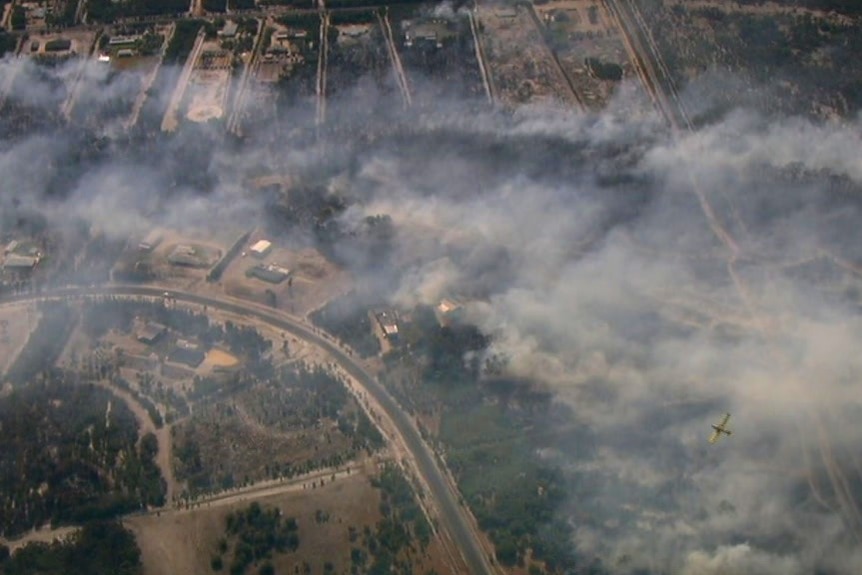 Aerial shot of smoke moving across a semi-rural sub-division