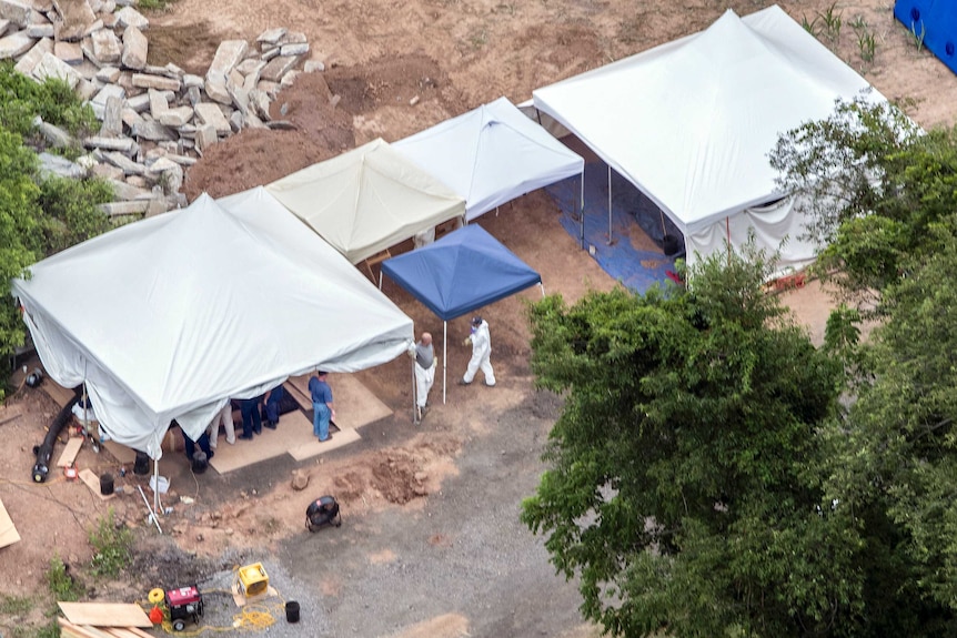 In this aerial photo, investigators work under tents as they search for clues in the disappearance of four men.