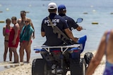 Police on quad bikes patrol a Tunisian beach near the hotel where a gunman shot 38 people