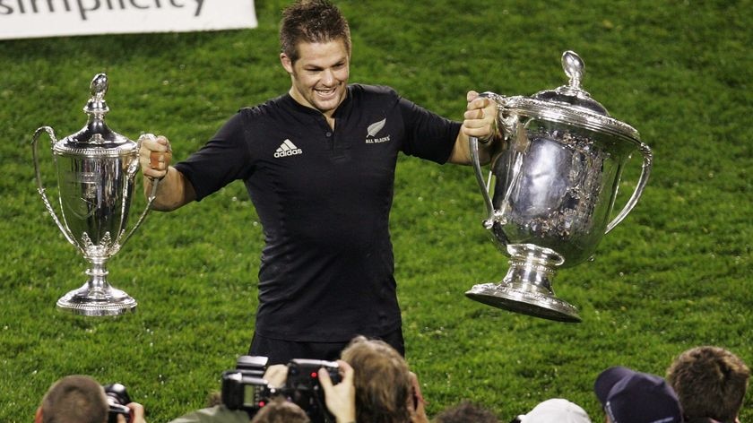 Winning silverware ... Richie McCaw holds the Bledisloe Cup and Tri-Nations trophies