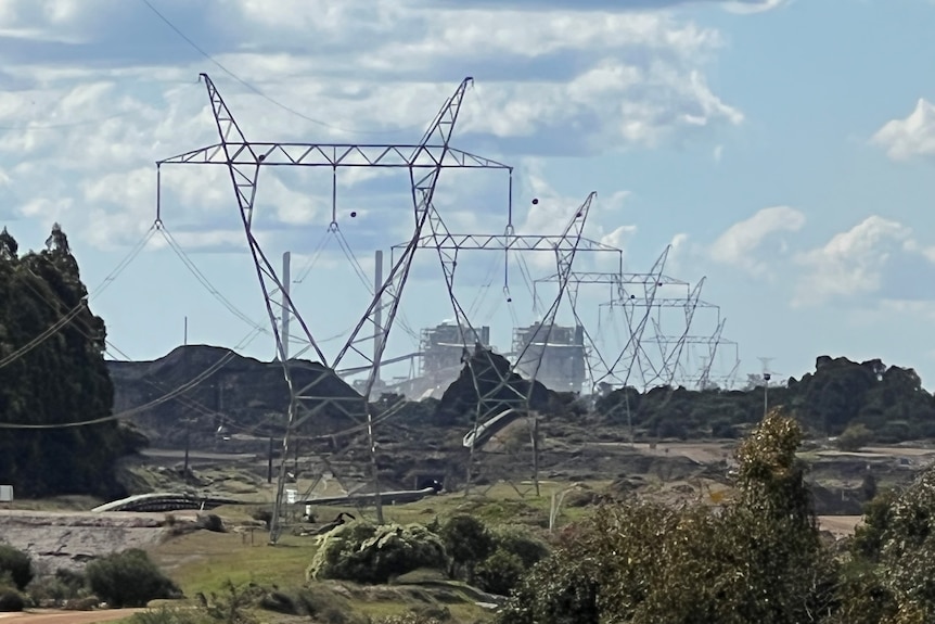 A long row of high-voltage transmission lines leading from a power station.