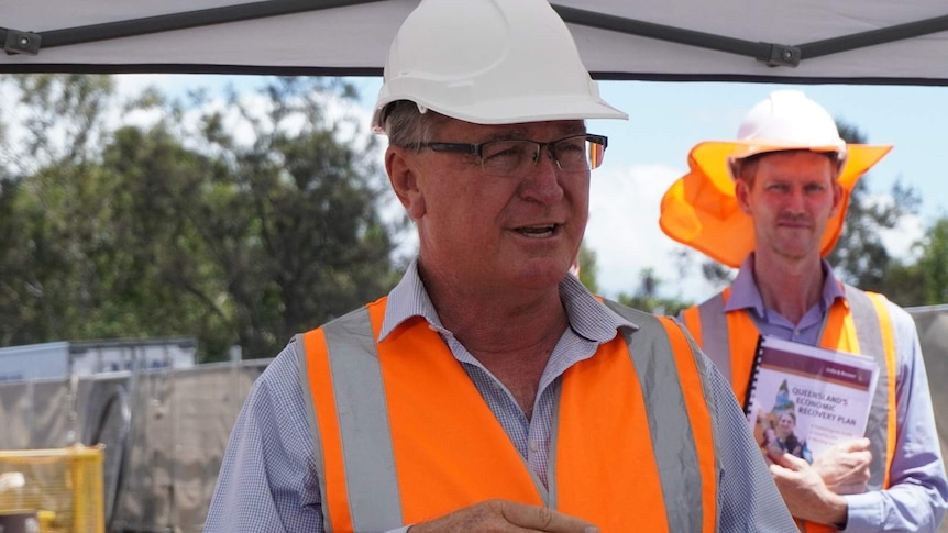 A middle-aged man in a hard hat and hig-viz vest