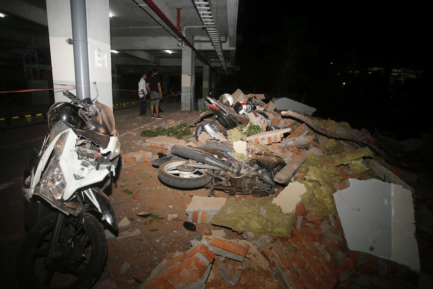 Debris on top of a motorcycles after an earthquake in Bali